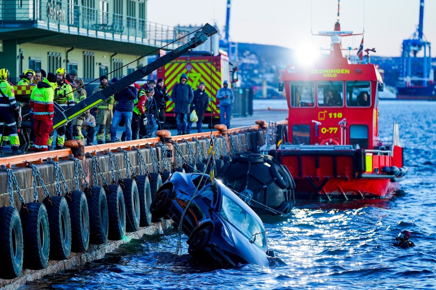 Feuerwehrleute bergen das versunkene Auto aus dem Fjord.