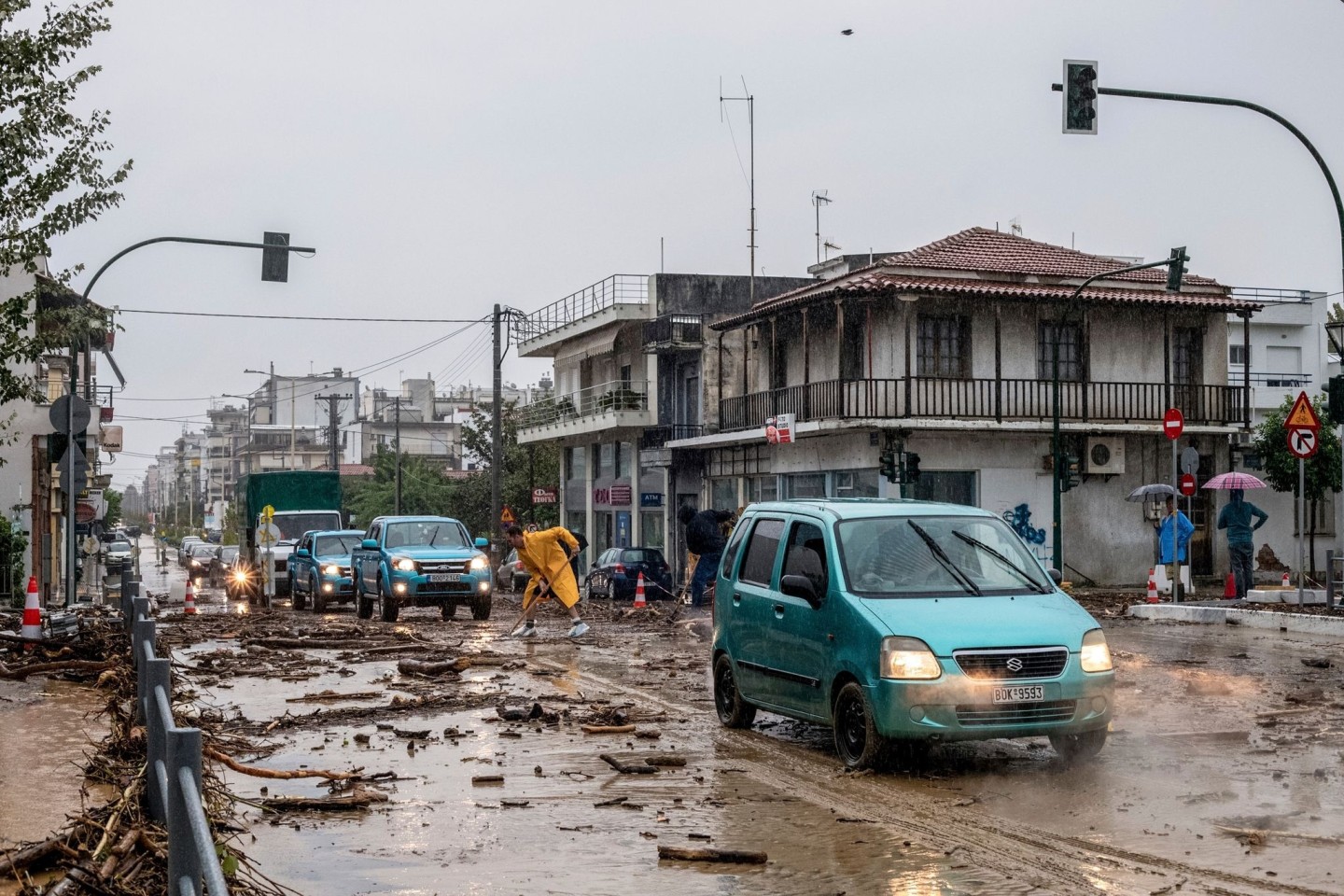 Ein Mann säubert die Straße nach dem Hochwasser in Volos.