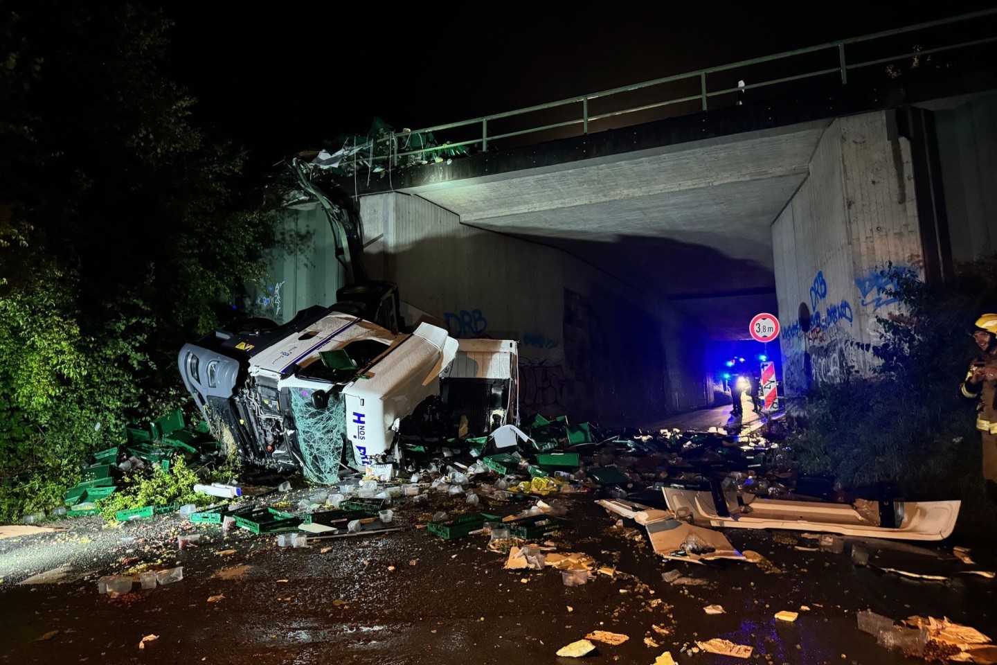 Ein Lkw ist von einer Autobahnbrücke auf eine darunterliegende Straße gestürzt. 