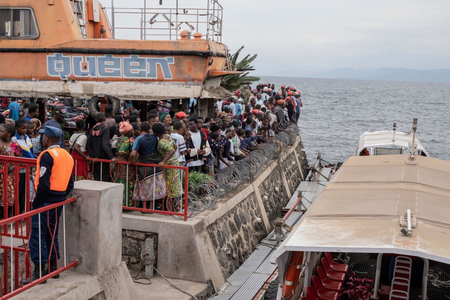 Nach dem Kentern einer Fähre versammeln sich Menschen am Hafen von Goma (aktuell)