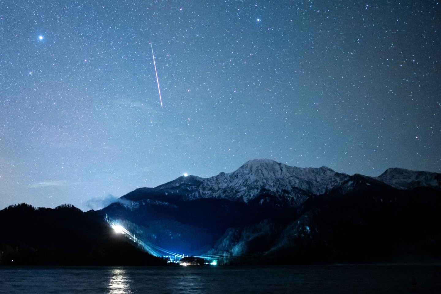 Eine Sternschnuppe ist über dem Kochelsee zu sehen.