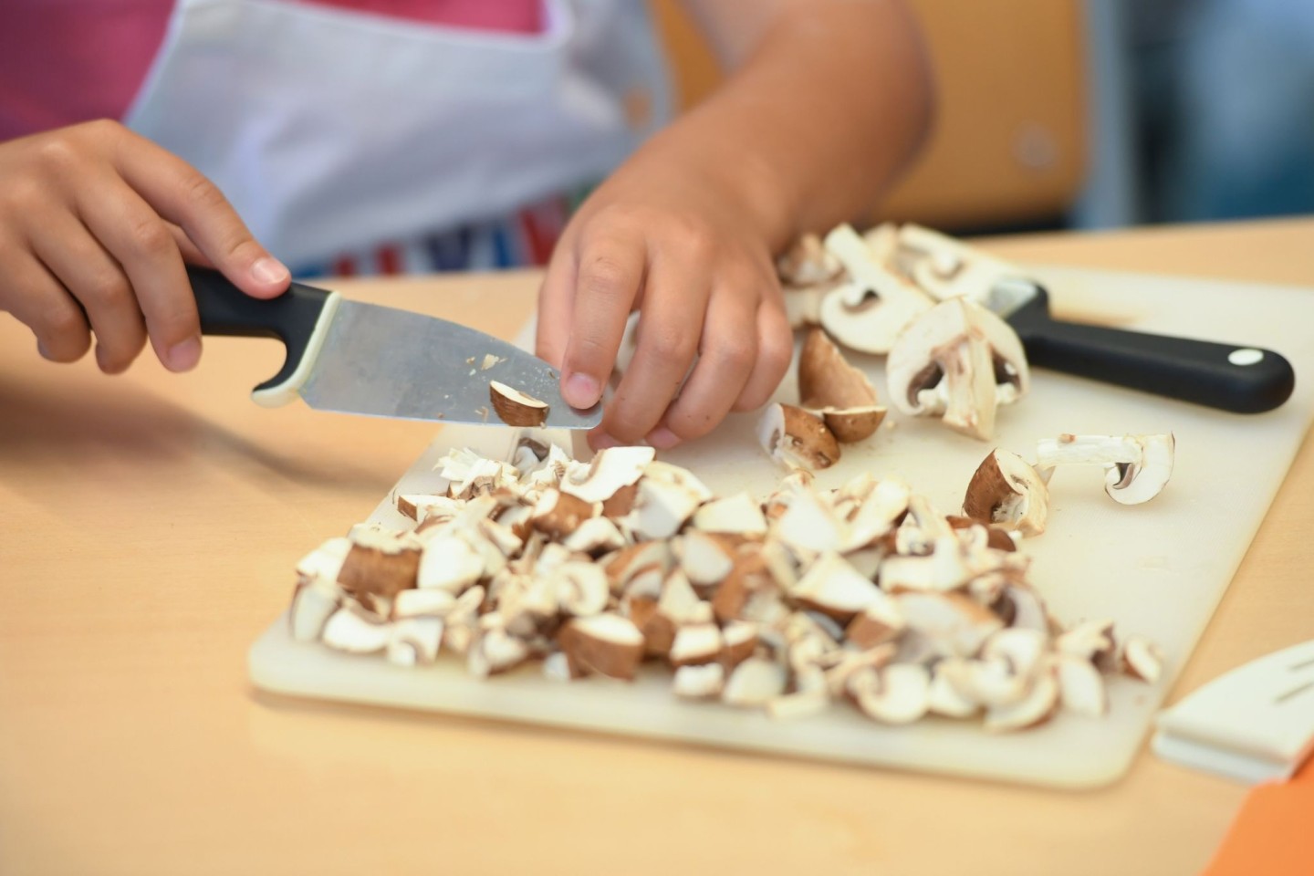 Eine Schülerin schneidet während der Koch AG Champignons in kleine Scheiben.