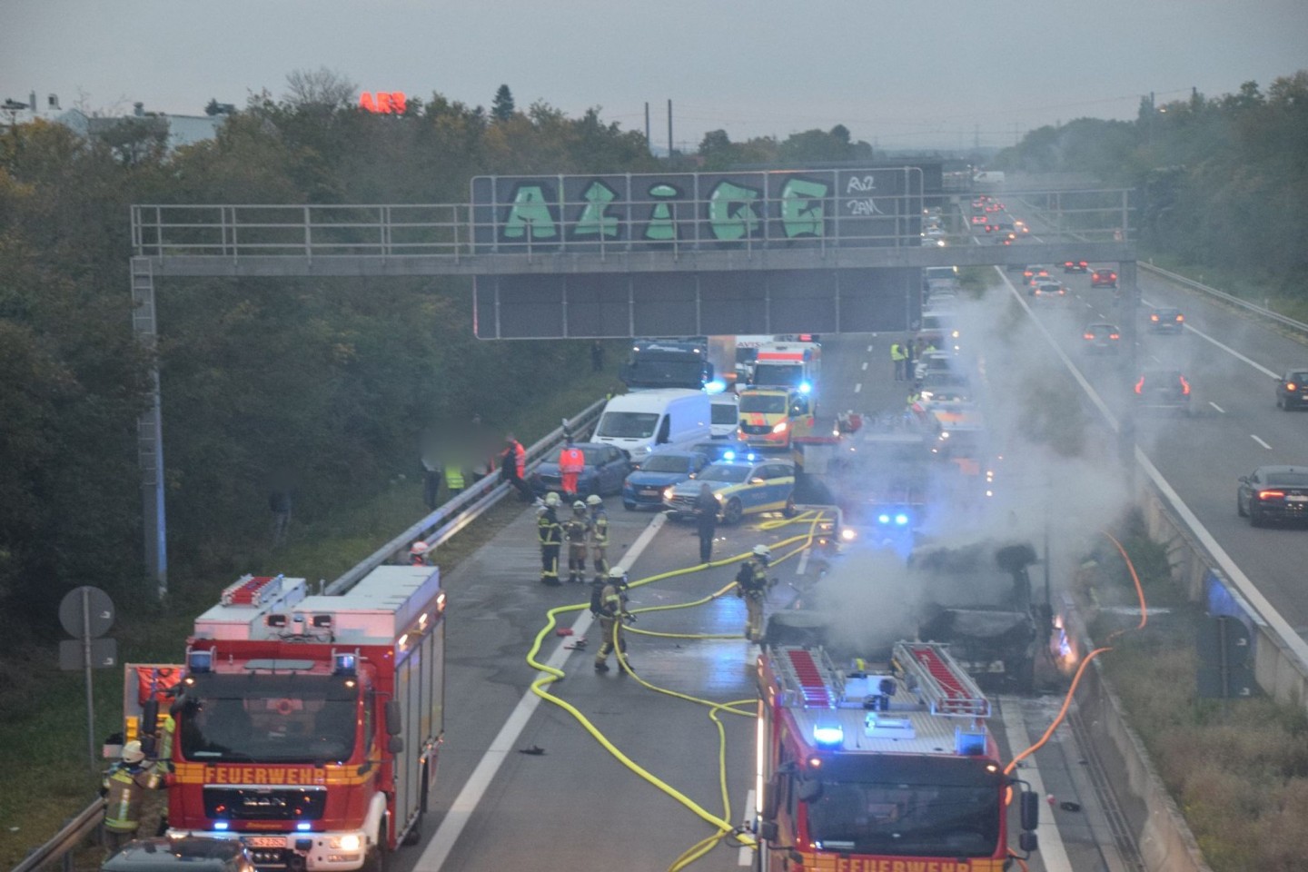 Zahlreiche Einsatzkräfte der Feuerwehr bei Löscharbeiten an einem brennenden Fahrzeug auf der A5.