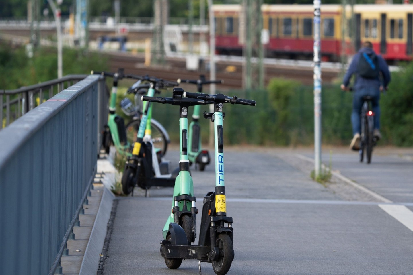 Elektroroller verschiedener Anbieter stehen nahe dem Berliner Bahnhof Ostkreuz auf einem Gehweg.