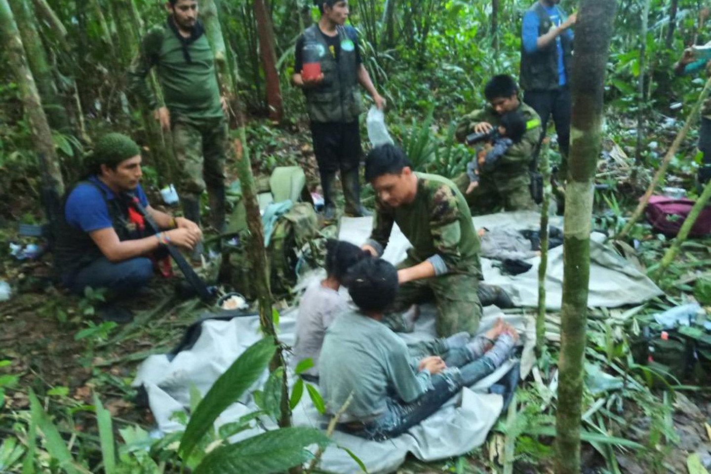 Soldaten und indigene Männer kümmern sich um die vier Geschwister, die nach dem Flugzeugabsturz vermisst wurden.